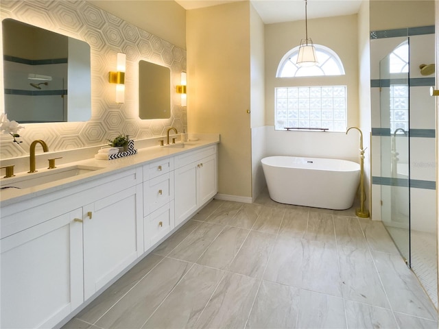 full bath featuring a walk in shower, a soaking tub, a sink, and double vanity