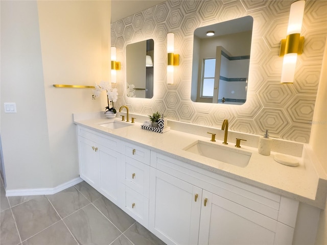 bathroom featuring a sink, baseboards, and double vanity