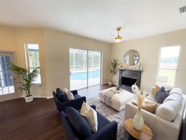 living area featuring a premium fireplace, baseboards, and dark wood finished floors