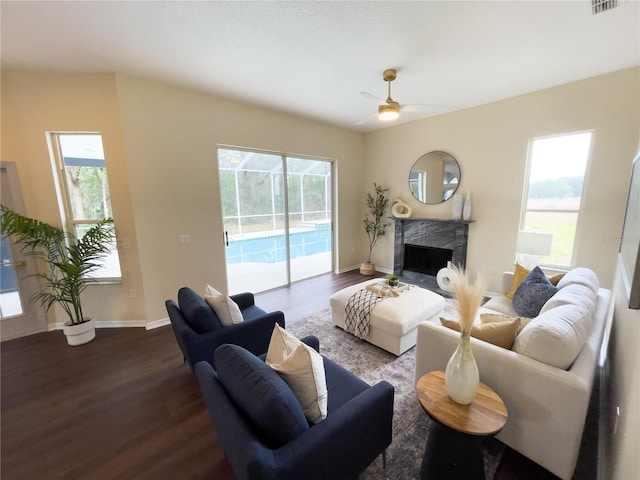 living room with baseboards, dark wood finished floors, and a high end fireplace