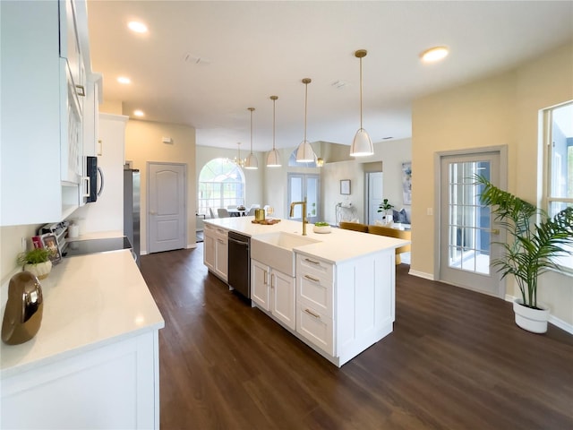 kitchen with dark wood finished floors, appliances with stainless steel finishes, white cabinets, and a sink