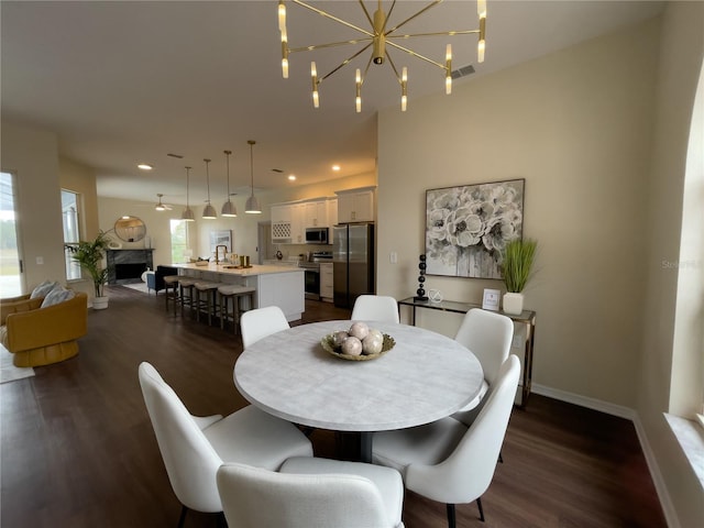 dining space with recessed lighting, dark wood-style flooring, a fireplace, and baseboards