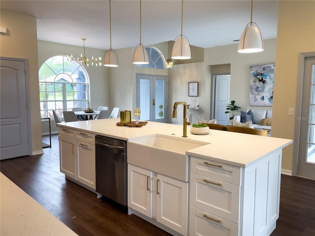 kitchen featuring dark wood finished floors, light countertops, dishwasher, and a sink