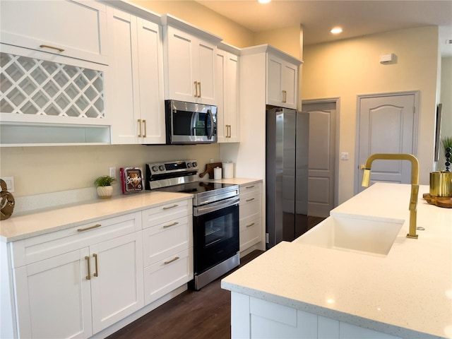 kitchen featuring appliances with stainless steel finishes, recessed lighting, white cabinets, and dark wood-style floors