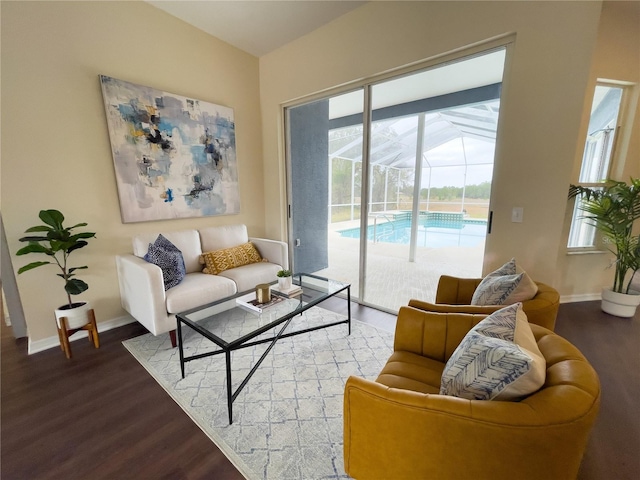 living area featuring wood finished floors, a sunroom, and baseboards