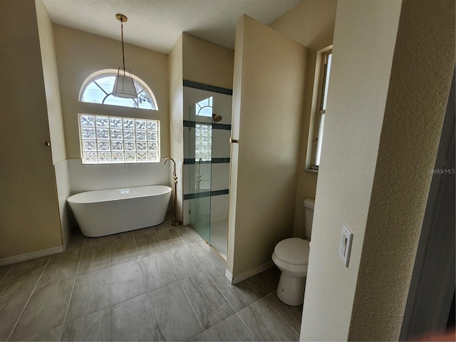 full bath with a soaking tub, a shower stall, toilet, and baseboards