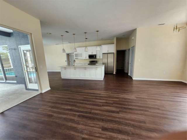 kitchen featuring white cabinets, open floor plan, dark wood-style flooring, stainless steel appliances, and light countertops