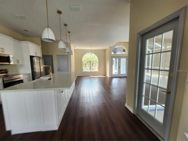 kitchen featuring appliances with stainless steel finishes, light countertops, visible vents, and white cabinetry