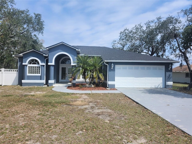 single story home with french doors, stucco siding, fence, a garage, and driveway