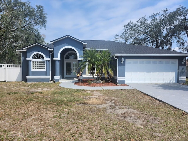 ranch-style home with french doors, stucco siding, concrete driveway, fence, and a garage