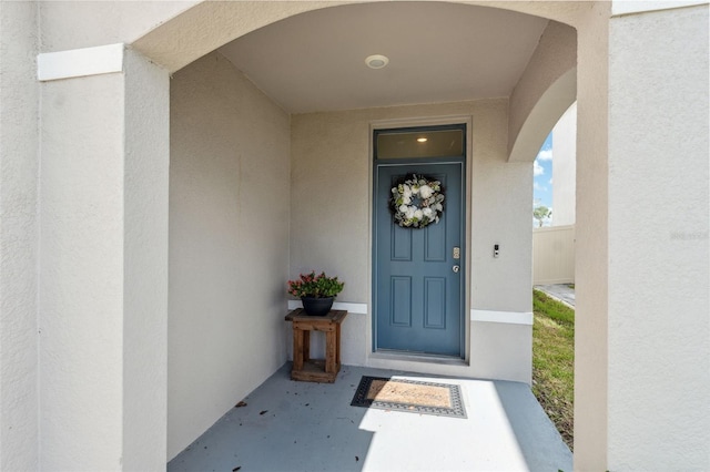 doorway to property featuring stucco siding