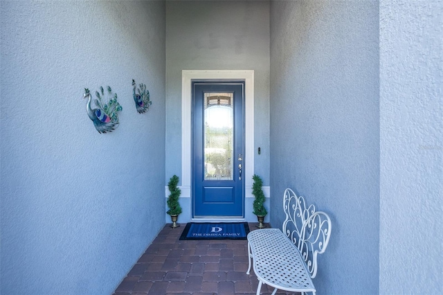 view of exterior entry featuring stucco siding