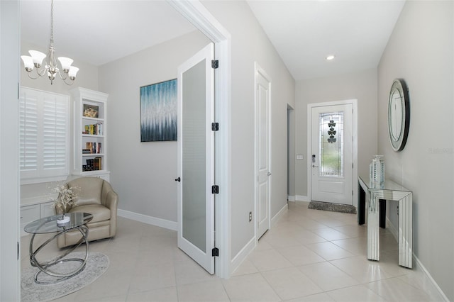 interior space with a chandelier, light tile patterned flooring, and baseboards