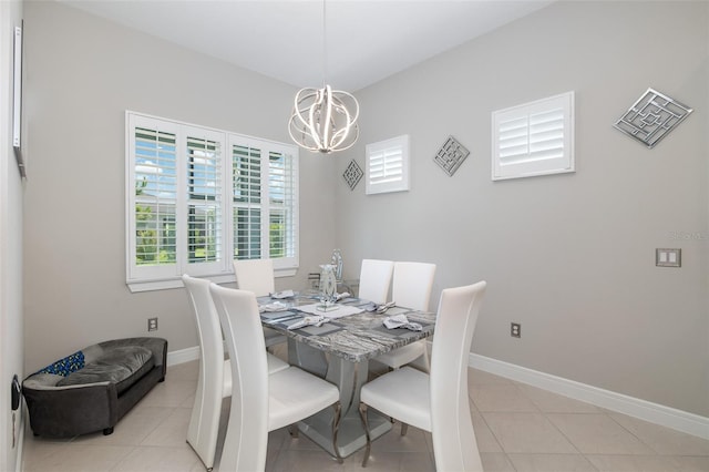 dining room with a chandelier, light tile patterned floors, and baseboards