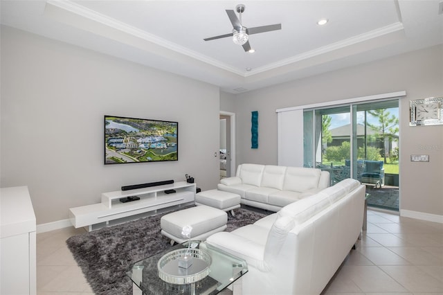 living area featuring light tile patterned floors, baseboards, and a tray ceiling