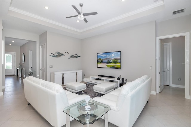 living room with ornamental molding, a raised ceiling, and visible vents