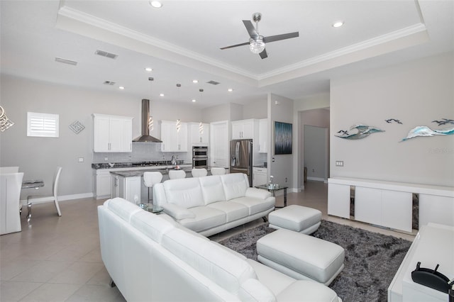 living room featuring a tray ceiling and crown molding