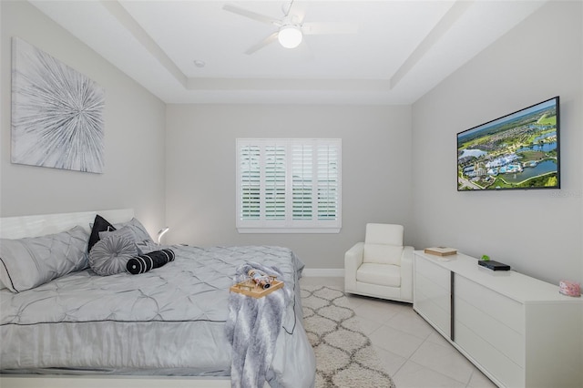 bedroom with a raised ceiling, ceiling fan, and light tile patterned floors