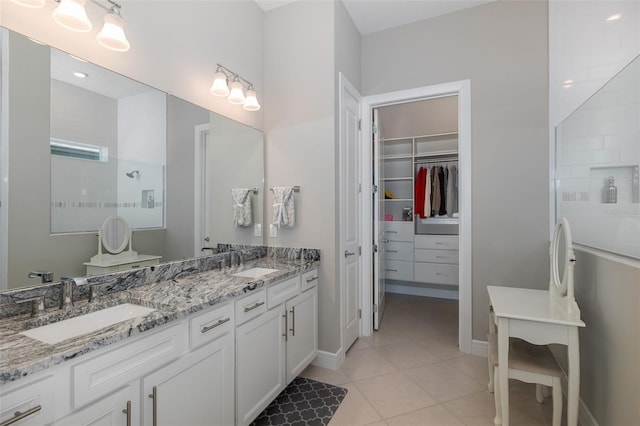 full bathroom featuring double vanity, walk in shower, tile patterned flooring, and a sink