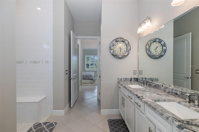 ensuite bathroom featuring tile patterned floors, a sink, ensuite bath, and double vanity