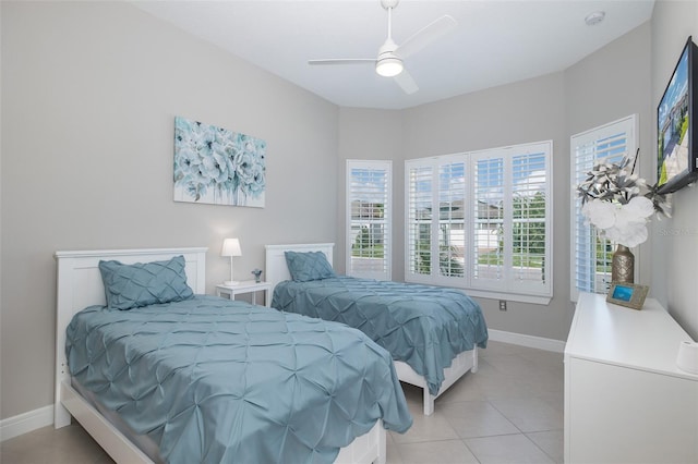 bedroom featuring light tile patterned floors, ceiling fan, and baseboards