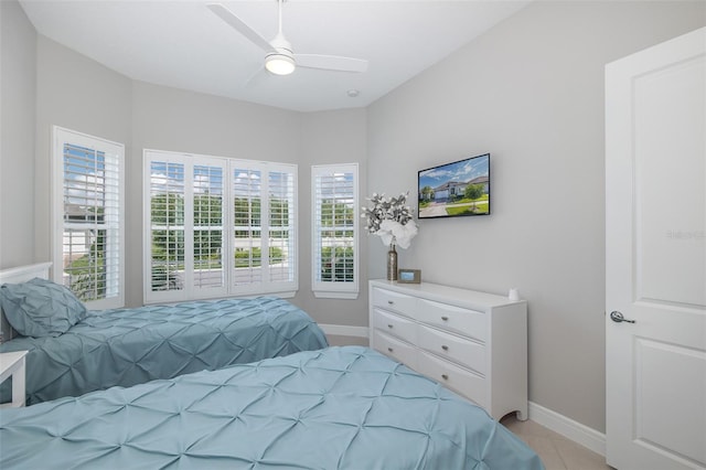 bedroom with light tile patterned floors, ceiling fan, and baseboards