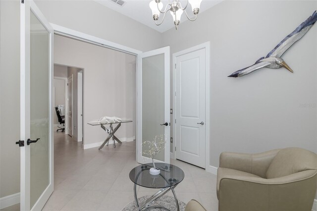 living area with baseboards and an inviting chandelier