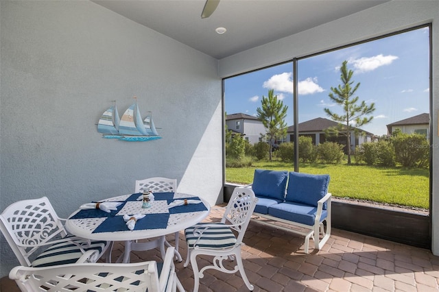 sunroom / solarium featuring a ceiling fan