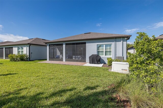 rear view of house with a sunroom, a lawn, and stucco siding