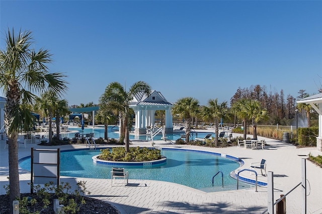 community pool with a patio and a pergola