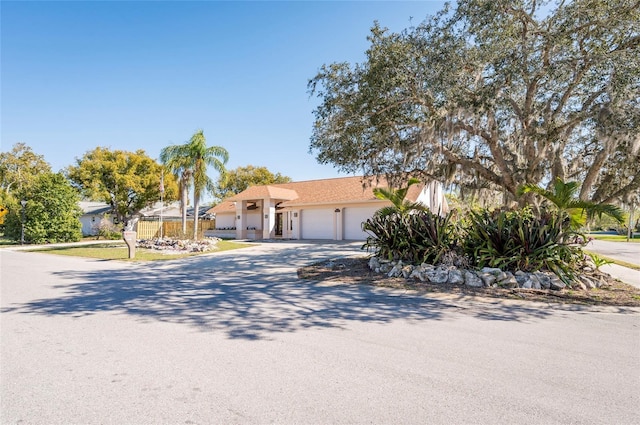 ranch-style house with an attached garage, driveway, and stucco siding