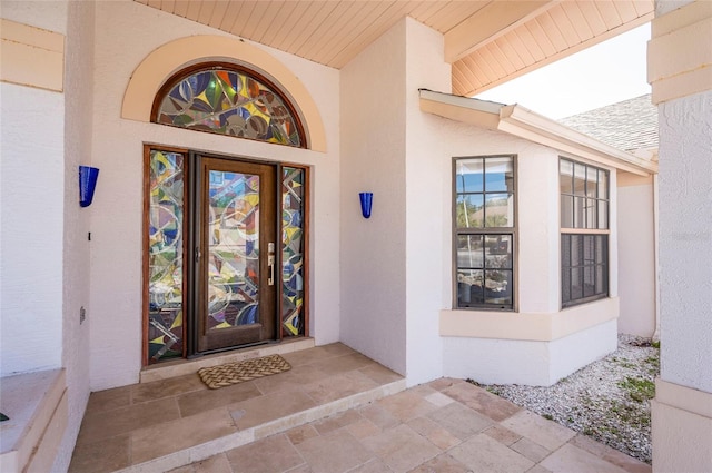 doorway to property featuring stucco siding