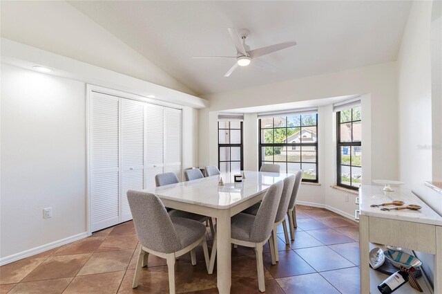 dining area with baseboards, lofted ceiling, light tile patterned flooring, and a ceiling fan