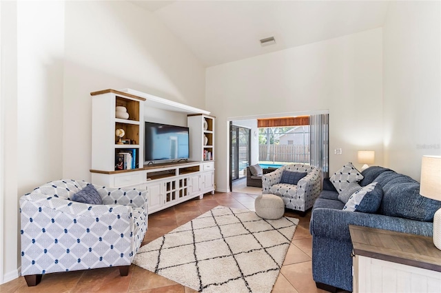 tiled living area with visible vents and high vaulted ceiling