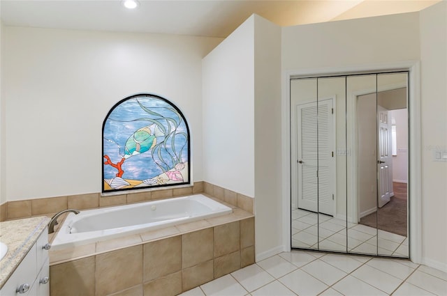 bathroom with a garden tub, vanity, and tile patterned flooring