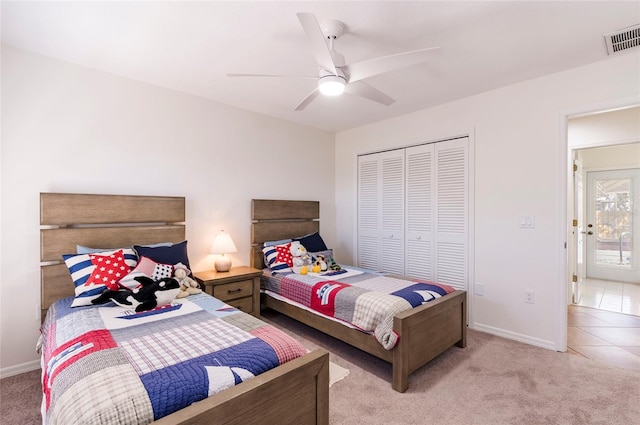 bedroom featuring a ceiling fan, light colored carpet, visible vents, and a closet