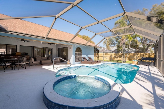 view of swimming pool featuring a pool with connected hot tub, a lanai, an outdoor hangout area, a patio area, and a ceiling fan