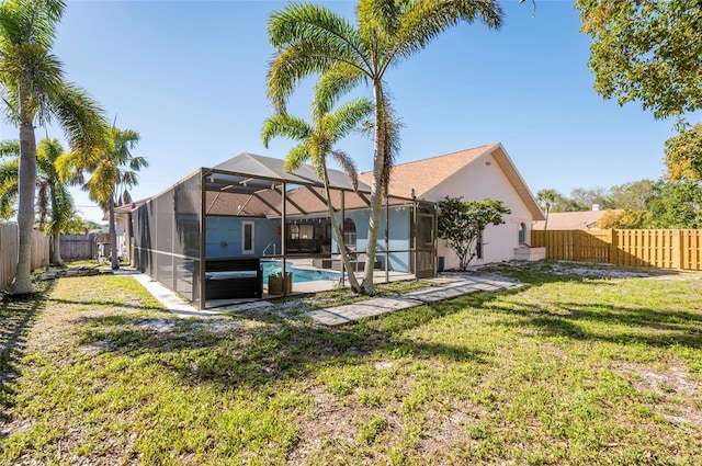 back of property featuring a lanai, a lawn, a fenced backyard, and a fenced in pool