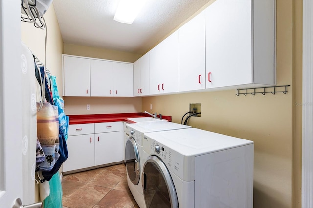 washroom with washer and clothes dryer, cabinet space, and a sink