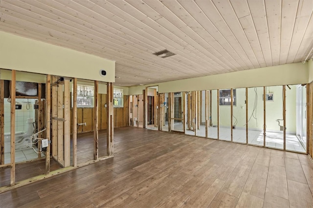unfurnished living room with visible vents, hardwood / wood-style floors, and wooden ceiling