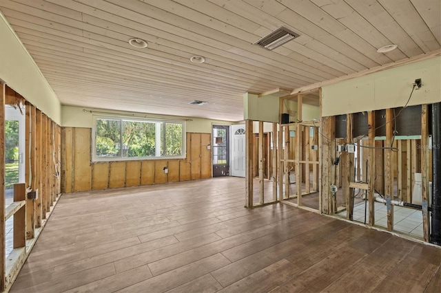 misc room with wooden walls, visible vents, wood ceiling, and hardwood / wood-style floors