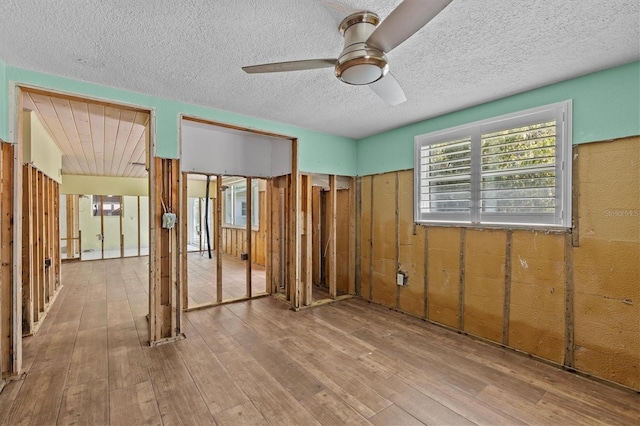 unfurnished bedroom featuring wood-type flooring, a textured ceiling, and ceiling fan