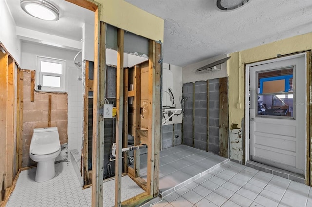 bathroom featuring a textured ceiling and toilet