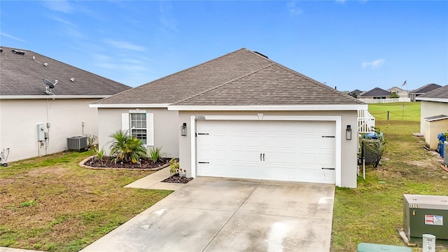 ranch-style home with central air condition unit, concrete driveway, roof with shingles, and a front yard