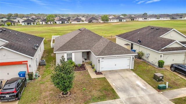 view of front of house featuring a residential view, concrete driveway, a garage, and roof with shingles