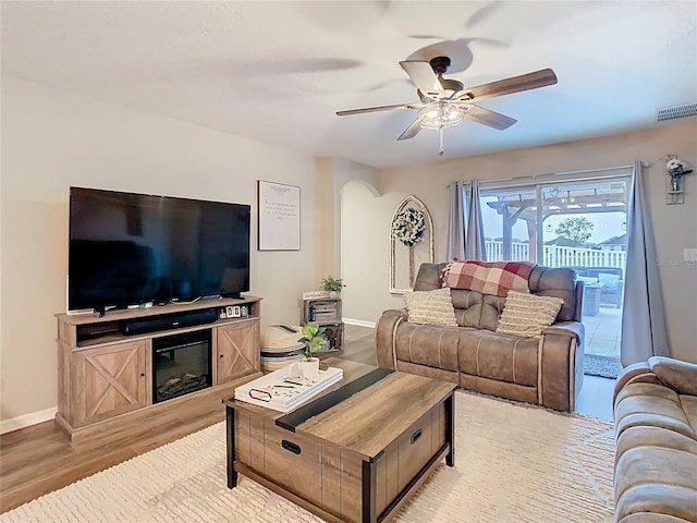 living room featuring visible vents, ceiling fan, baseboards, and light wood-style floors