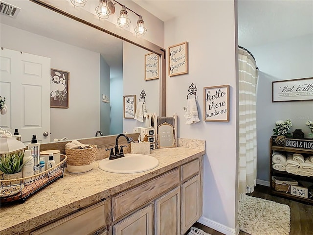 full bath featuring visible vents, baseboards, and vanity