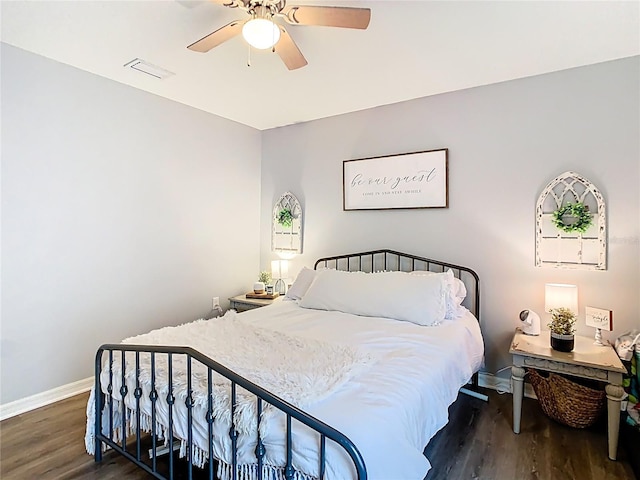 bedroom with ceiling fan, wood finished floors, visible vents, and baseboards