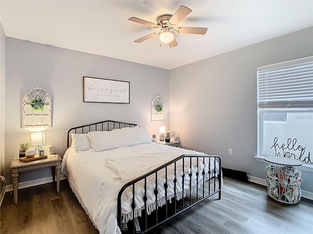 bedroom with ceiling fan, baseboards, and wood finished floors