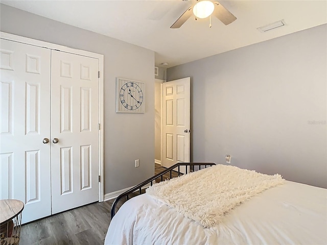 bedroom with a ceiling fan, dark wood-style floors, a closet, and baseboards